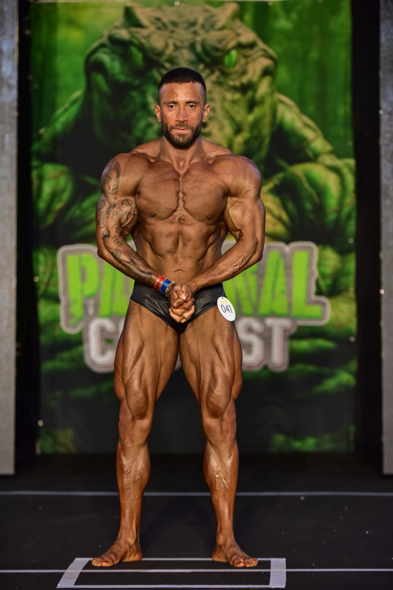 Diego Campos no palco do campeonato de fisiculturismo, em pose frontal